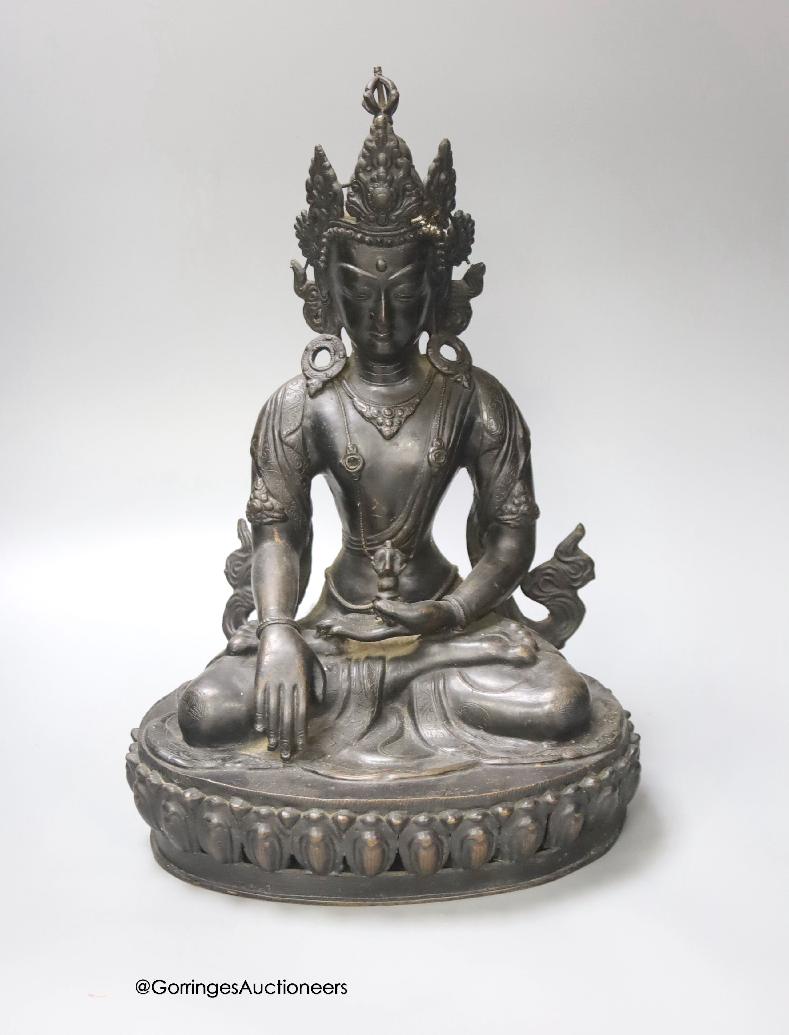 A bronze figure of a Bodhisattva, seated on an oval lotus base, 36cm